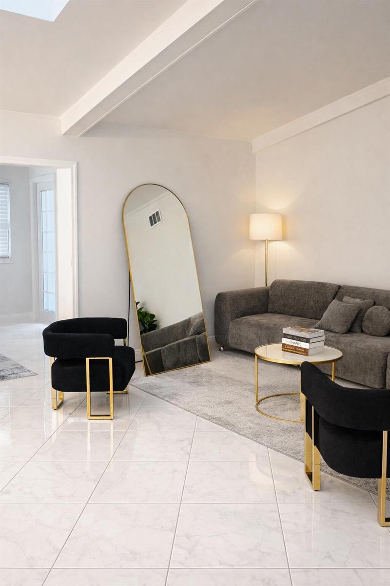 A living room features a grey sofa, two black chairs with gold frames, and an arched mirror — 9940 Liberty Road, Boca Raton FL 33434, BOCA RATON, FL