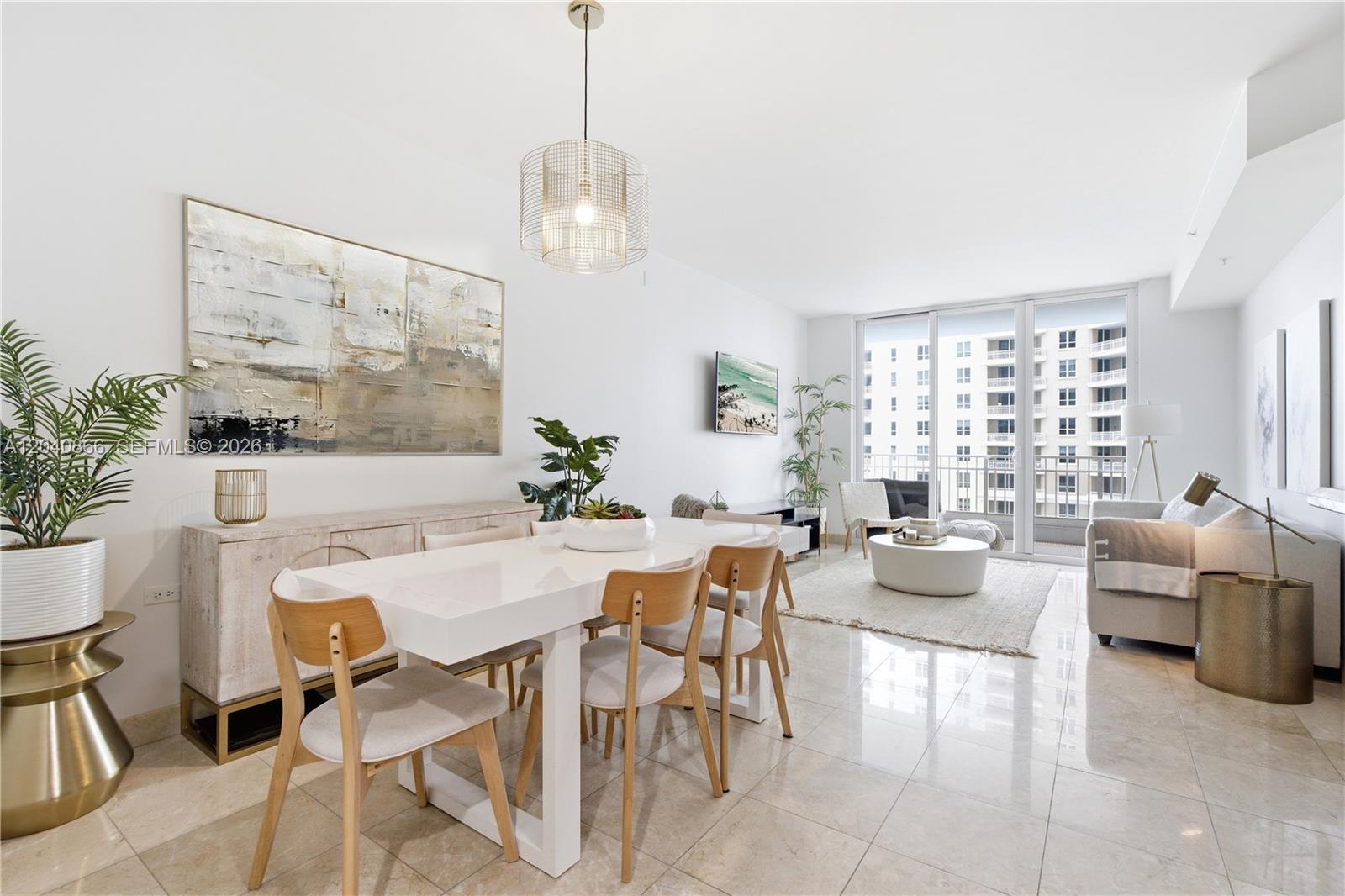 A bright, open-concept living and dining area features white tile floors, modern furniture, and balcony views — 801 Brickell Key Blvd # 707, Miami FL 33131, MIAMI, FL