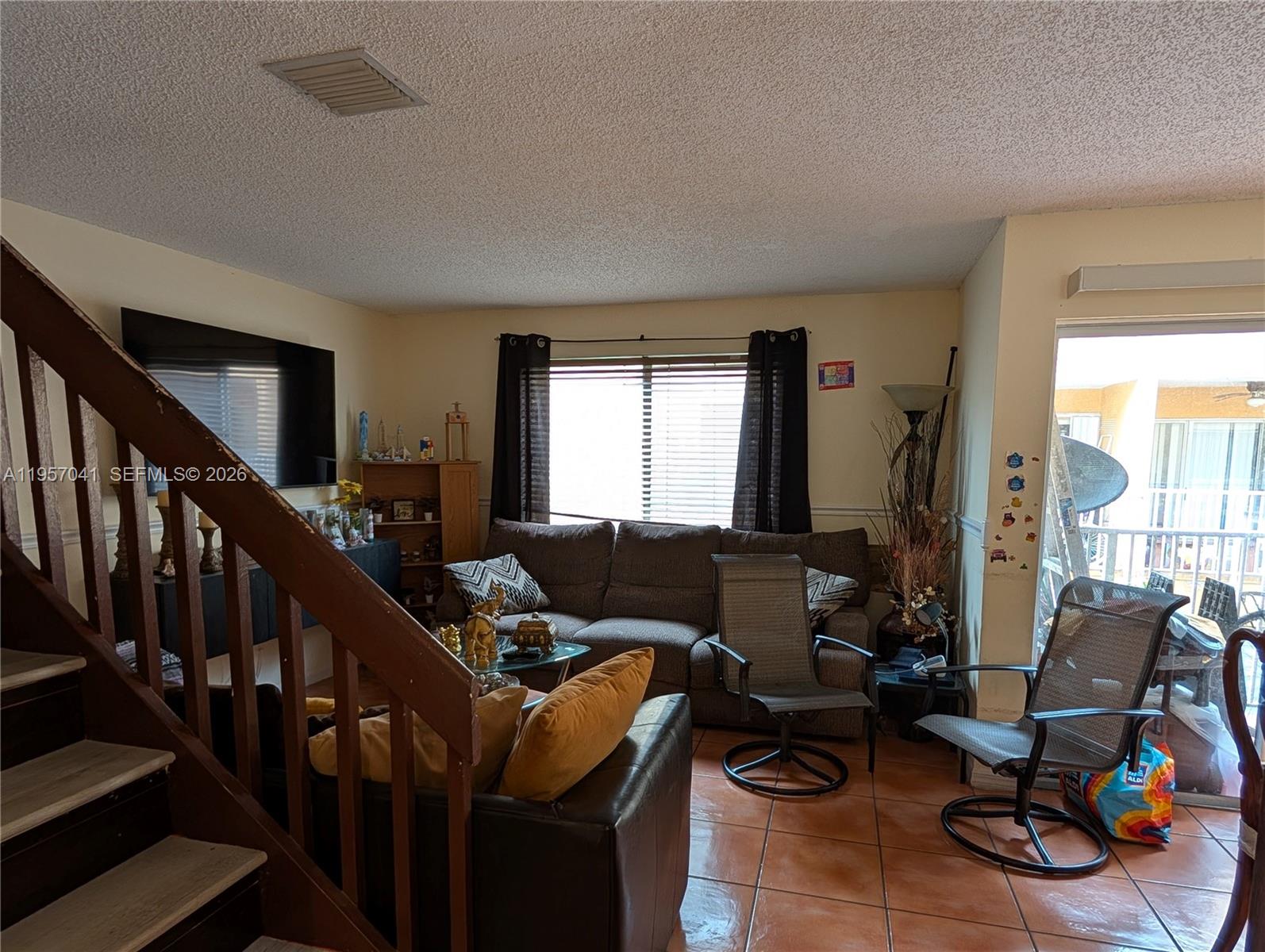 A living room features a staircase, a sofa, two swivel chairs, and tile flooring — 6205 Kendale Lakes Cir # 289, Miami FL 33183, MIAMI, FL