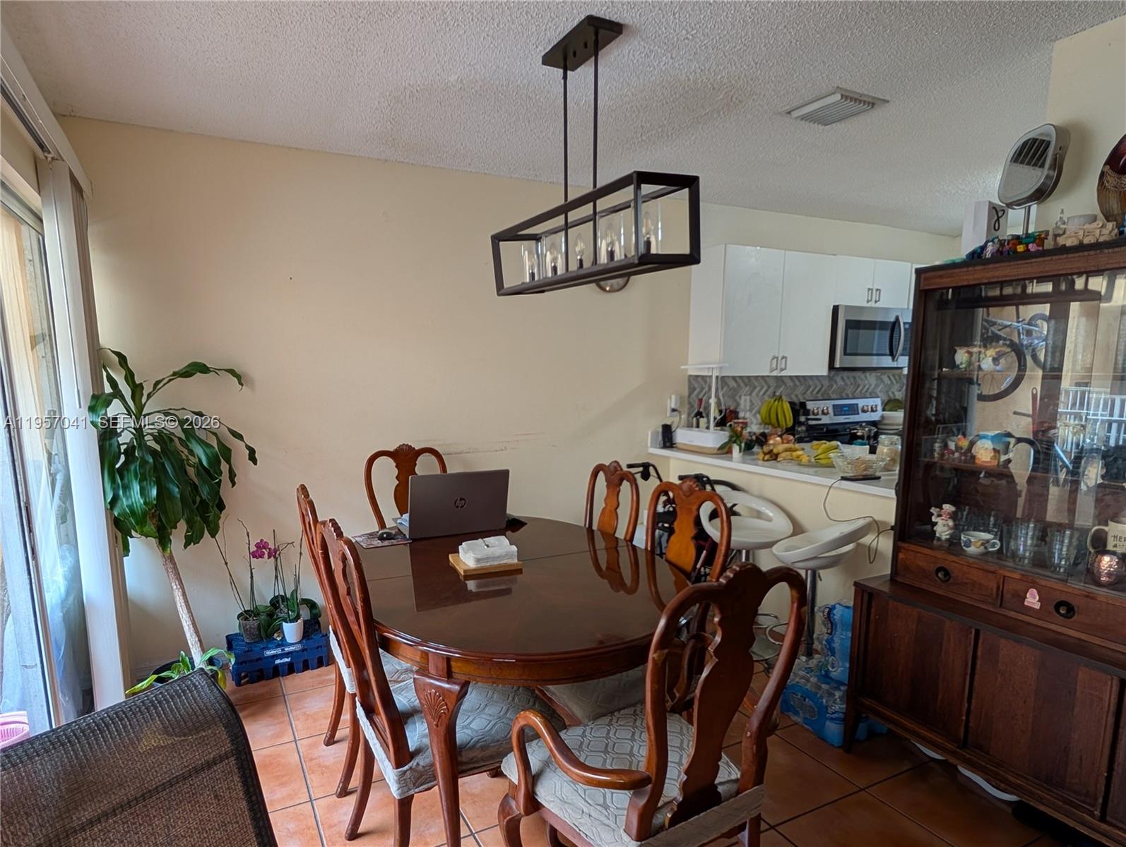 A dining area features a wooden table, chairs, a hanging light fixture, and a china cabinet — 6205 Kendale Lakes Cir # 289, Miami FL 33183, MIAMI, FL