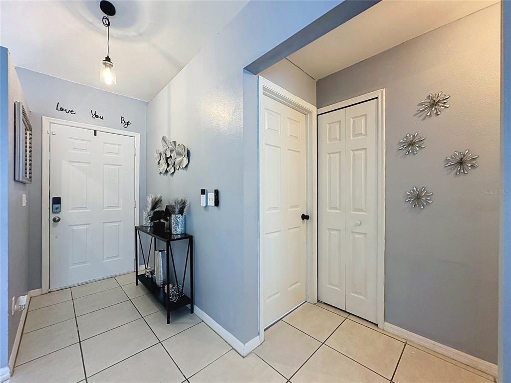 An entryway features light gray walls, tiled flooring, a console table, and two white doors — 240 SUNRISE RD, DAVENPORT, FL