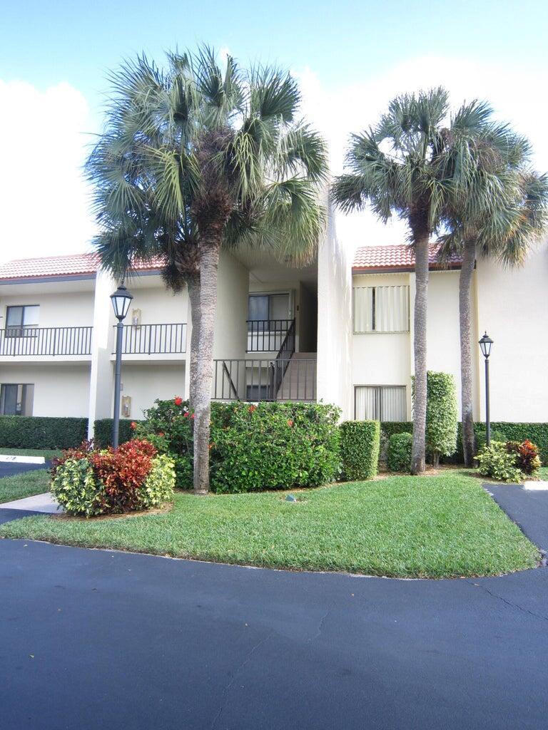 A two-story apartment building exterior features palm trees, manicured hedges, and a central staircase — 1605 S Us Highway 1, Jupiter FL 33477, JUPITER, FL