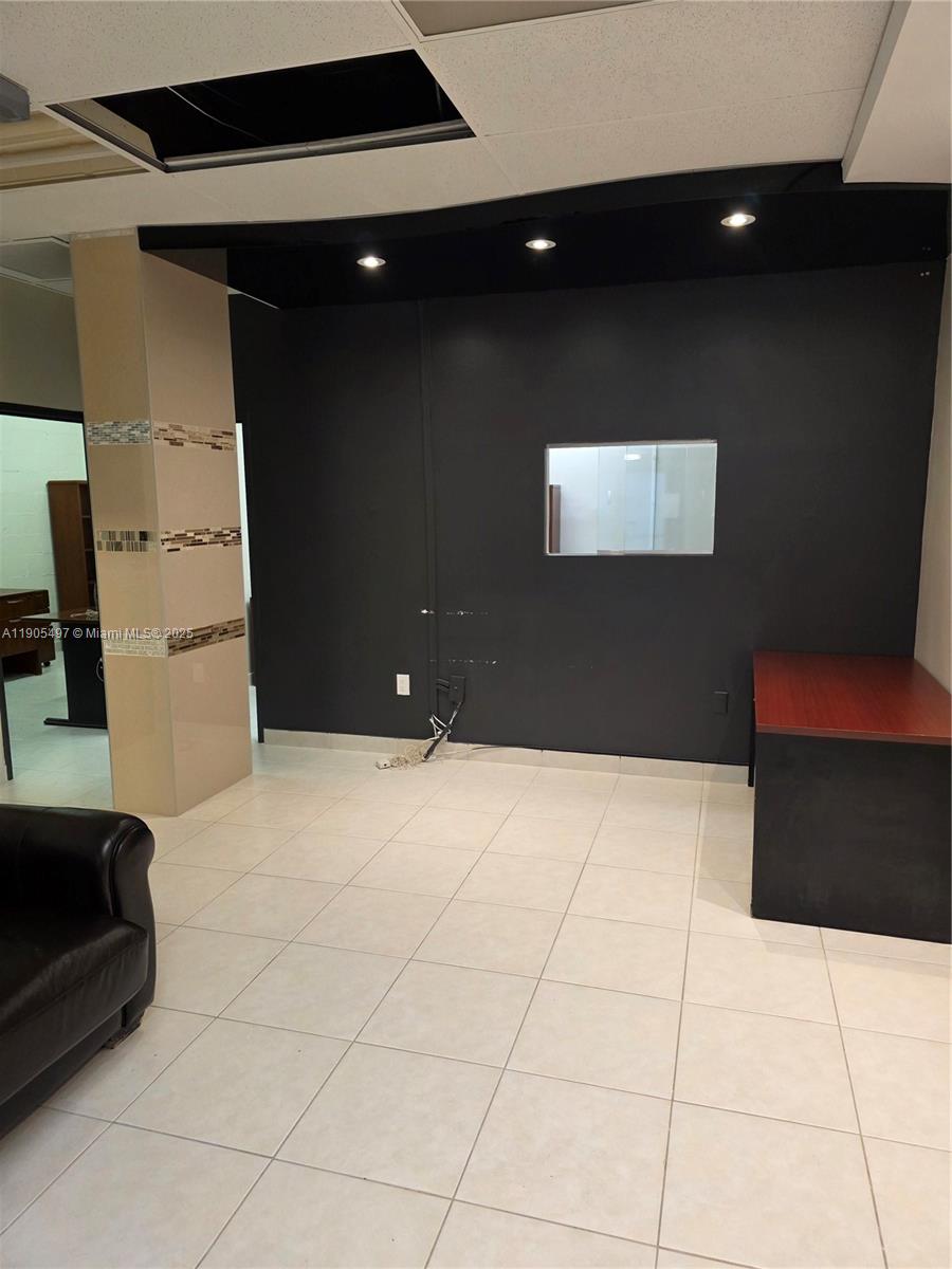 An office space features a dark accent wall, a tiled floor, and a built-in desk — 1985 S Ocean Dr # 3L, Hallandale Beach FL 33009, HALLANDALE BEACH, FL