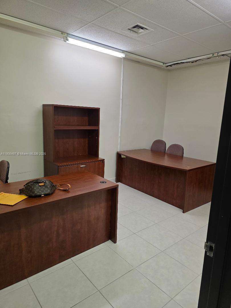 An office room features two wooden desks, a matching bookshelf, and light-colored floor tiles — 1985 S Ocean Dr # 3L, Hallandale Beach FL 33009, HALLANDALE BEACH, FL