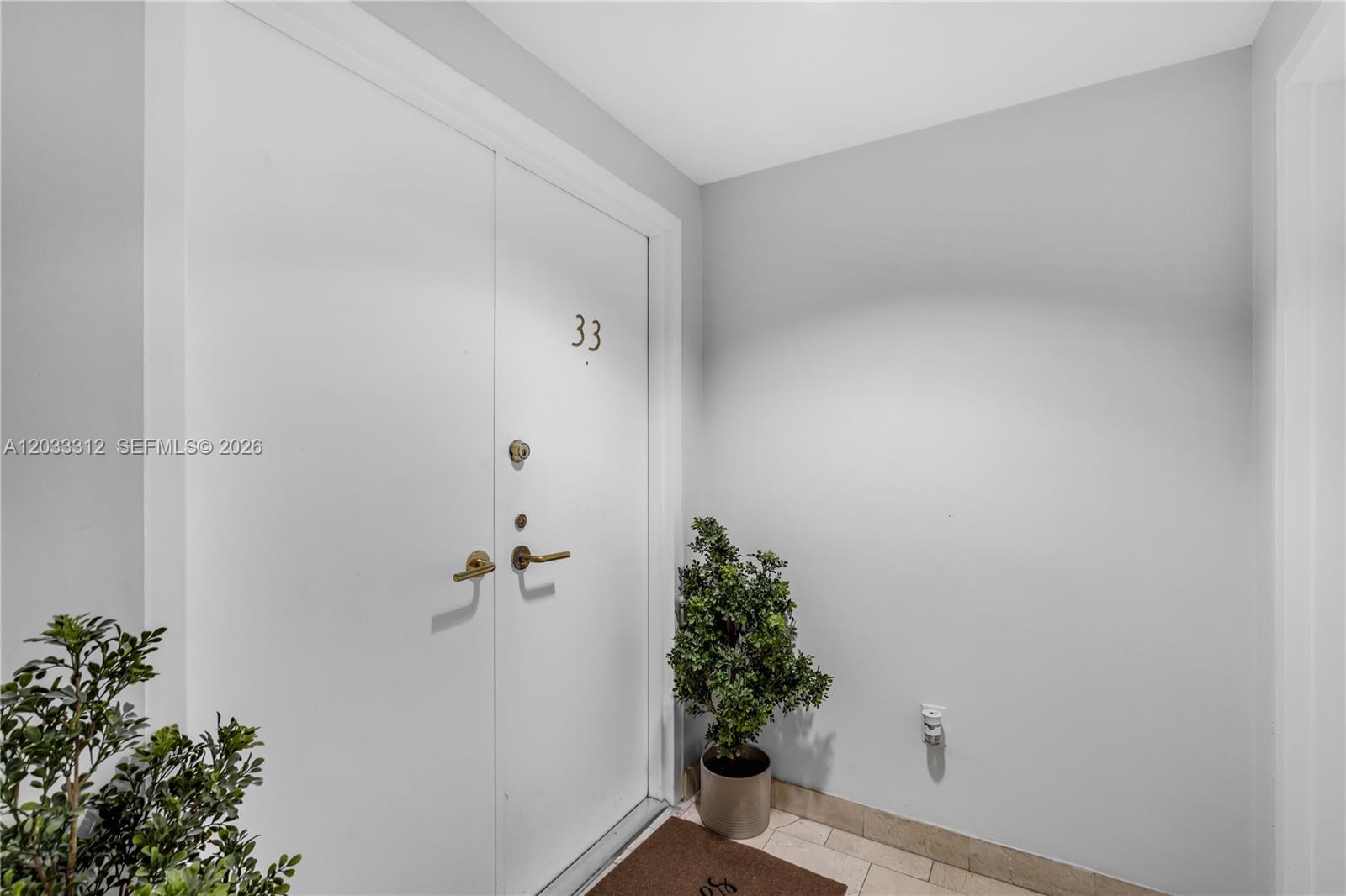 A white double door with the number 33 is flanked by potted plants — 1834 Brickell Ave # 33, Miami FL 33129, MIAMI, FL