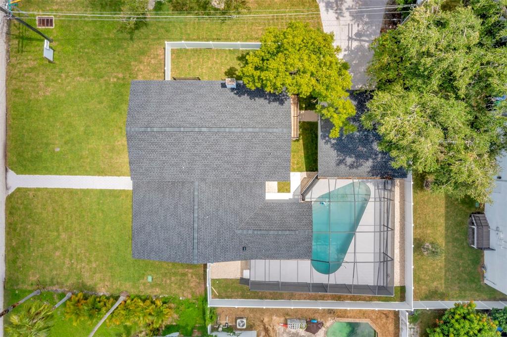 An aerial view shows a house with a dark shingled roof and a screened-in pool — 4902 W SAN RAFAEL STREET, TAMPA, FL
