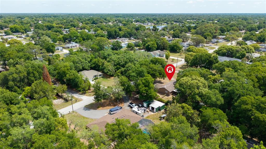 An aerial view shows a residential property with a house, outbuildings, and surrounding trees — 45 LAKE DRIVE, DEBARY, FL