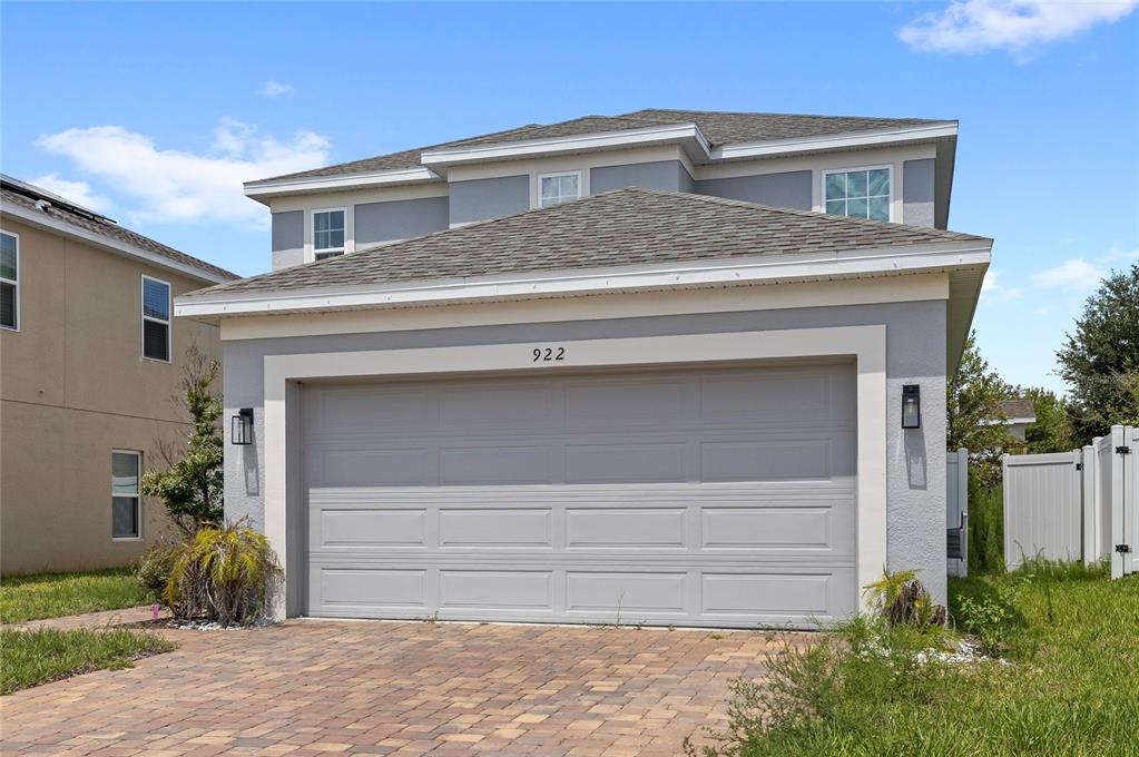 A two-story house with a gray stucco exterior and a two-car garage — 922 ANNA PLACE, DAVENPORT, FL