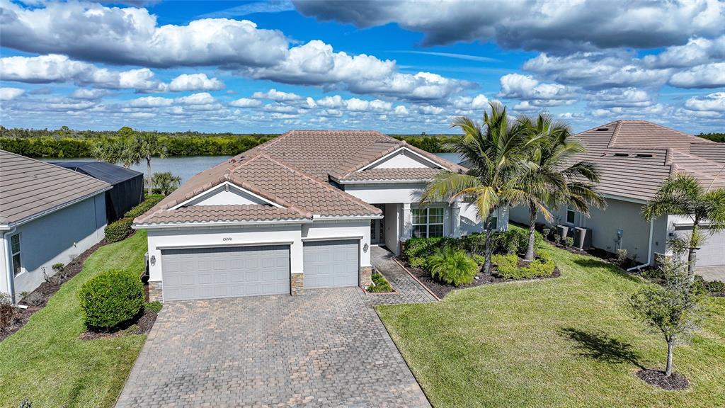 An aerial view of a single-story house with a paved driveway and a tile roof — 15240 SPANISH POINT DRIVE, PORT CHARLOTTE, FL