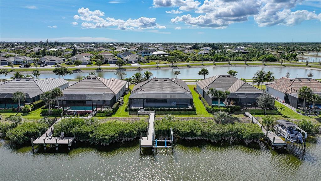 An aerial view shows several waterfront homes with screened-in pools and private boat docks — 15240 SPANISH POINT DRIVE, PORT CHARLOTTE, FL