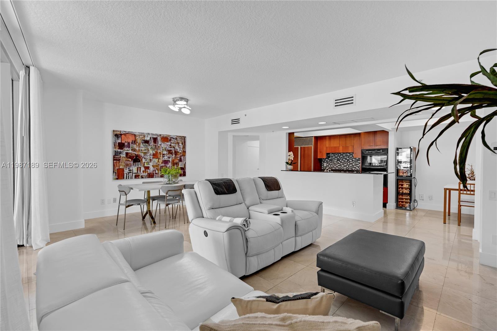 A living room and dining area feature white leather furniture, tile floors, and an open kitchen — 1500 Ocean Dr # 505, Miami Beach FL 33139, MIAMI BEACH, FL