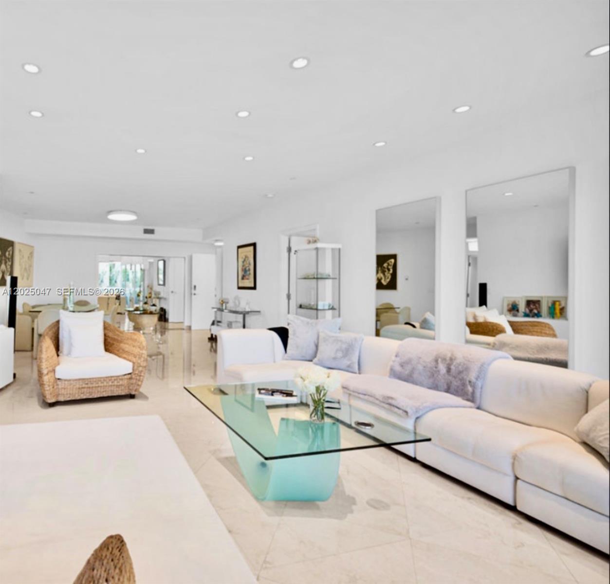 A bright living room features white walls, tile floors, a glass coffee table, and mirrors — 9601 Collins Ave # 403, Bal Harbour FL 33154, BAL HARBOUR, FL