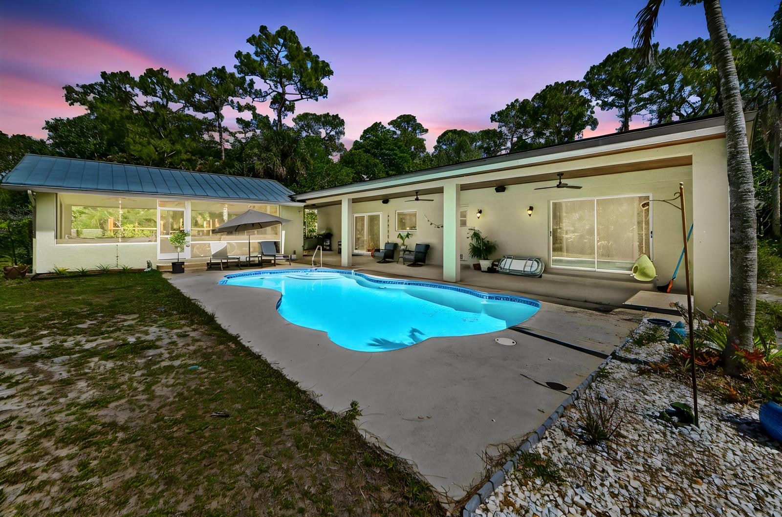A backyard features a kidney-shaped swimming pool, a covered patio, and a light-colored house exterior — 12369 157th Street N, Jupiter FL 33478, JUPITER, FL