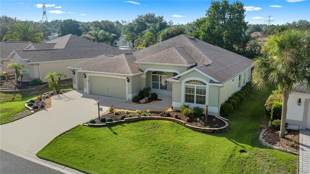 An aerial view of a single-story suburban house with a tan exterior and tile roof — 346 PACOLET TERRACE, THE VILLAGES, FL