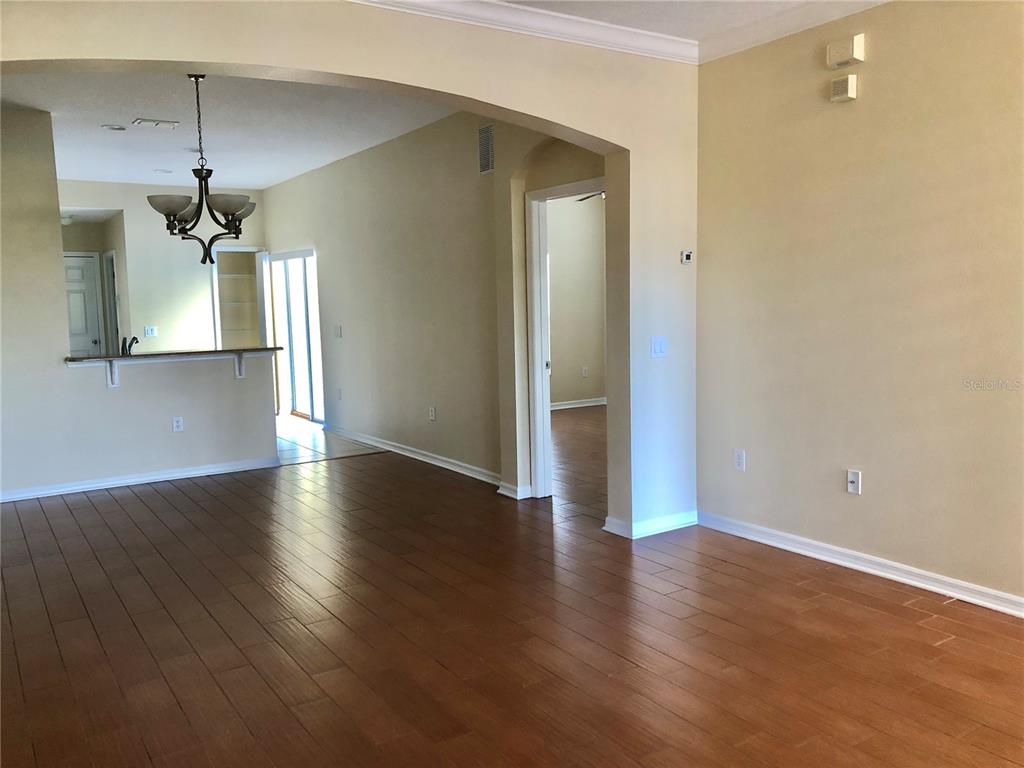An interior view shows a living area with hardwood floors, beige walls, and an arched entryway — 5567 SOMERSBY ROAD, WINDERMERE, FL
