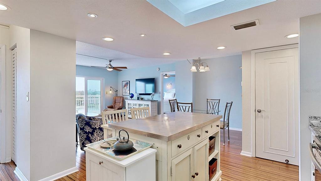 An open-concept kitchen with a central island overlooks a living area and dining space — 4900 BRITTANY DRIVE S UNIT 1011, ST PETERSBURG, FL