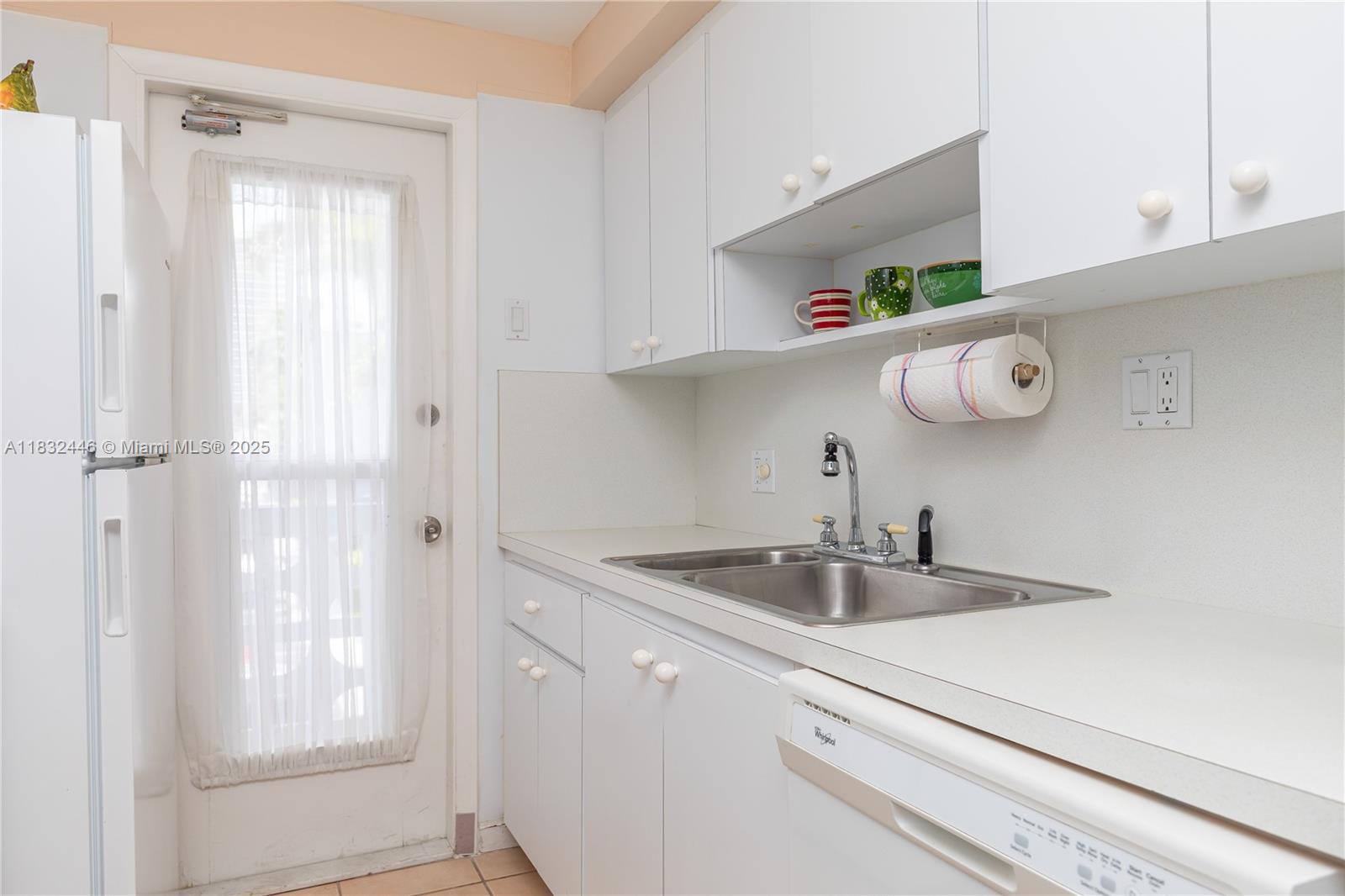 A kitchen features white cabinets, a stainless steel sink, and a white dishwasher — 3135 S Ocean Dr # 230, Hallandale Beach FL 33009, HALLANDALE BEACH, FL