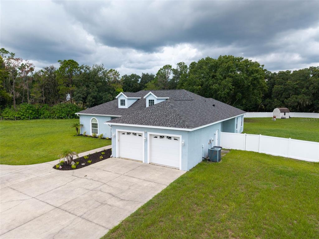 An aerial view of a light blue house with a two-car garage and dormer windows — 1318 LITTLE ALAFIA DRIVE, PLANT CITY, FL