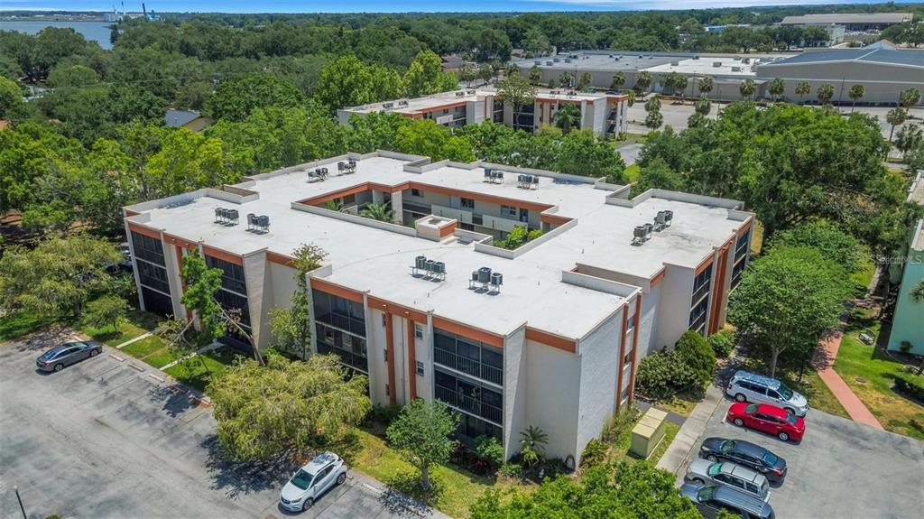 An aerial view of a multi-story apartment complex with a central courtyard and parking lot — 1130 N LAKE PARKER AVENUE UNIT C229, LAKELAND, FL
