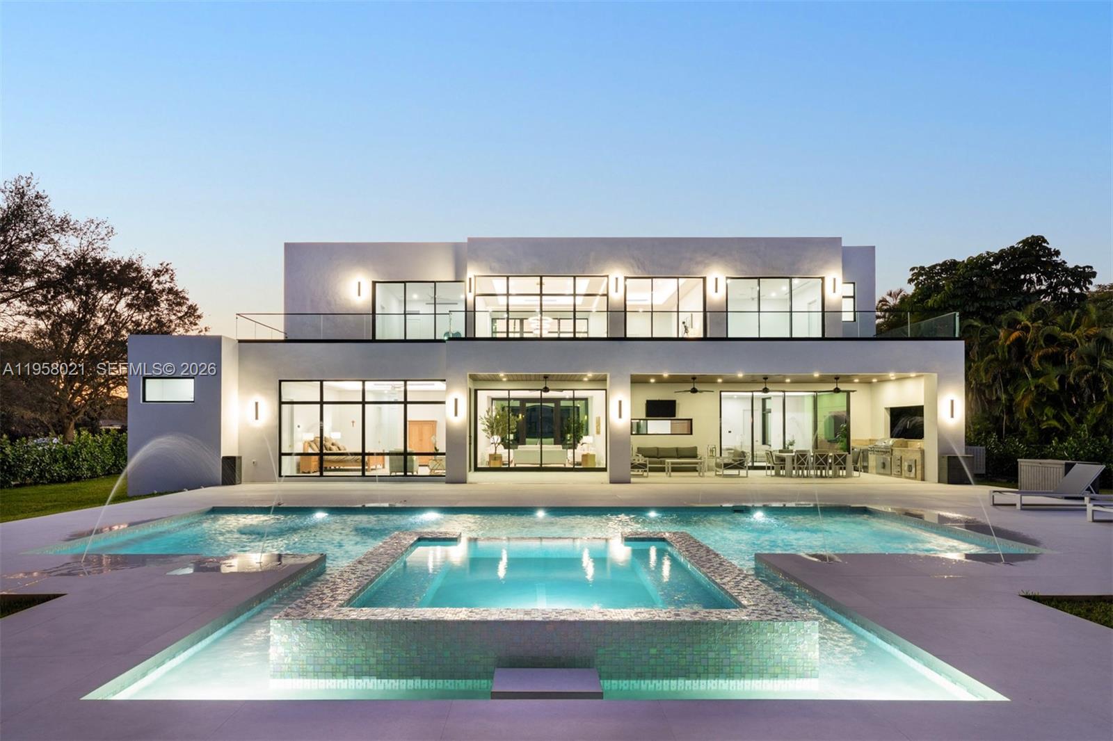A modern two-story house features a large swimming pool with a central tiled spa — 9525 SW 95th Ct, Miami FL 33176, MIAMI, FL