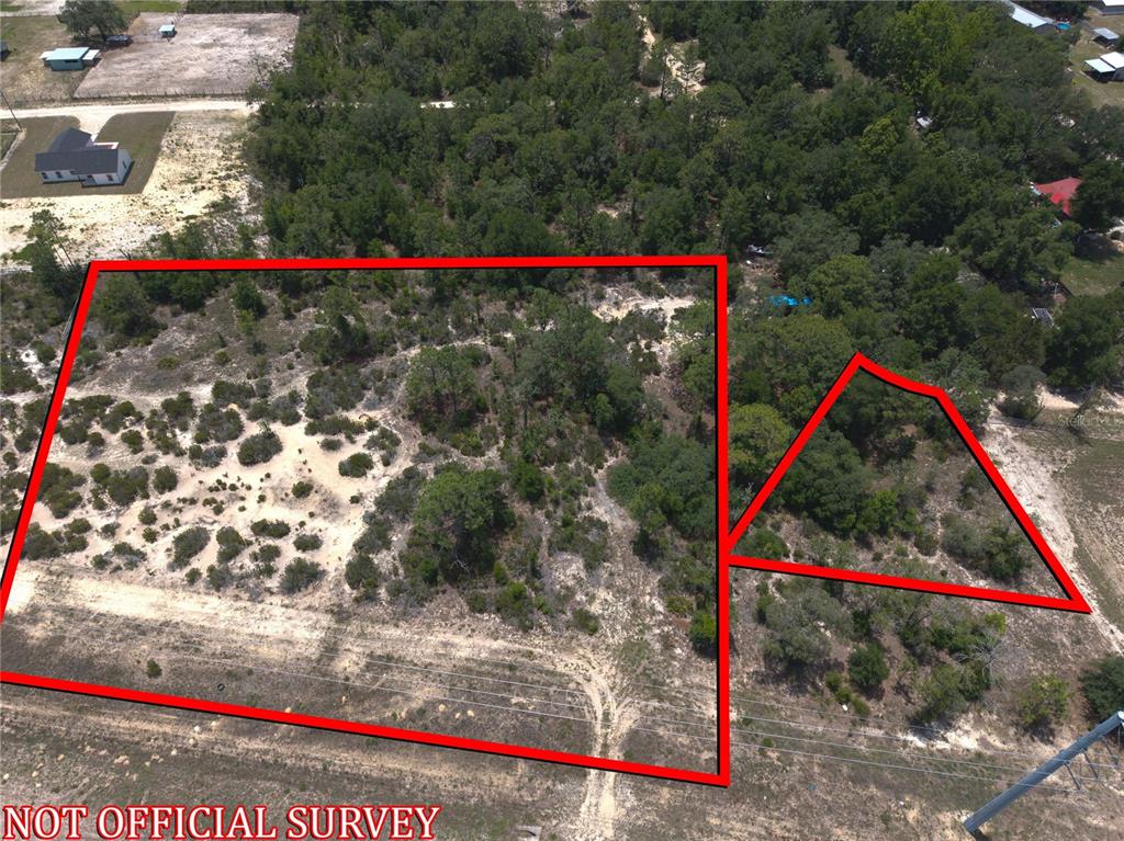 An aerial view shows two adjacent plots of undeveloped, wooded land outlined in red — 000 NE HWY 27 ALT, WILLISTON, FL