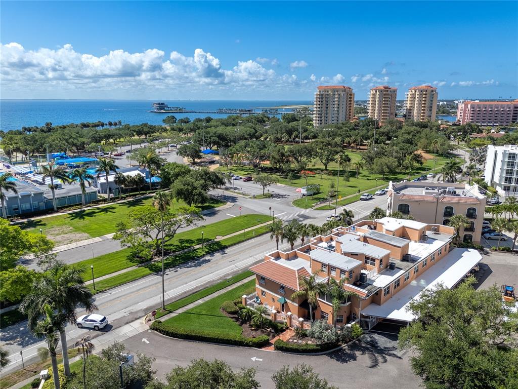 An aerial view shows a multi-story building near a park, parking lot, and the ocean — 920 NORTH SHORE DRIVE NE, ST PETERSBURG, FL