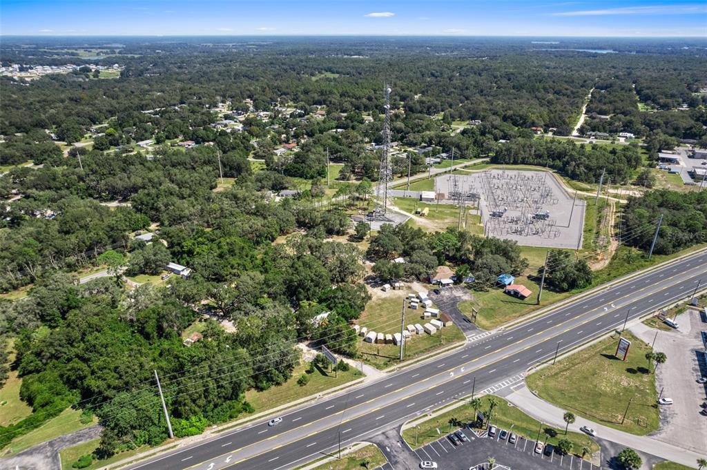 An aerial view shows a multi-lane road, a large electrical substation, and a communication tower — 3865-3899 E GULF TO LAKE HIGHWAY, INVERNESS, FL