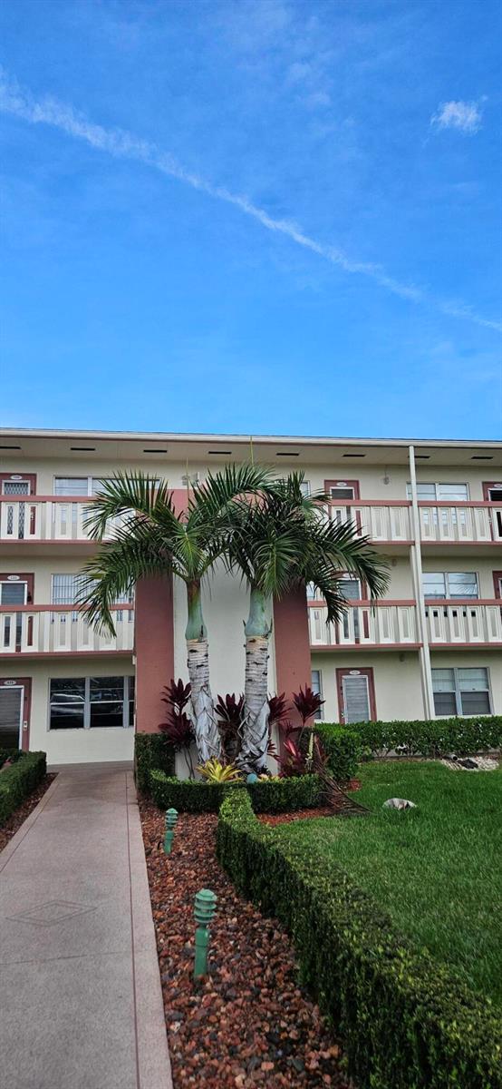 A multi-story apartment building exterior featuring a palm tree in front of a walkway — 198 E Preston Way # 198, Boca Raton FL 33434, BOCA RATON, FL