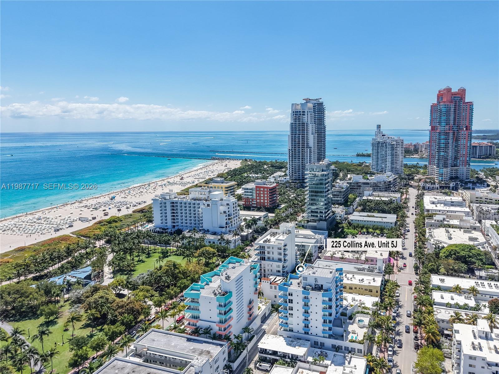 An aerial view shows a coastal city with high-rise buildings, a beach, and parks — 225 Collins Ave # 5J, Miami Beach FL 33139, MIAMI BEACH, FL