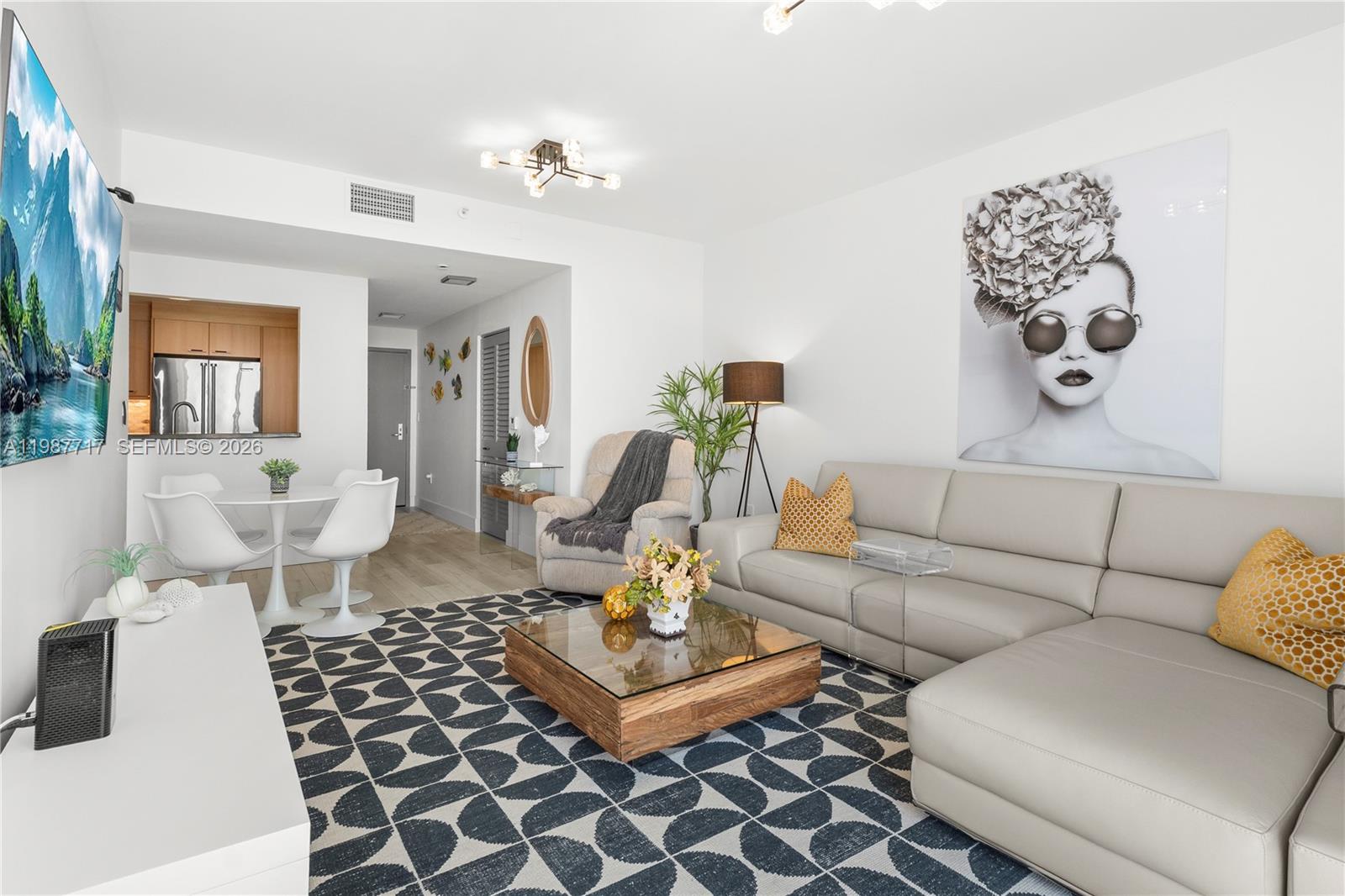A living room features a sectional sofa, a patterned rug, and a glass-topped coffee table — 225 Collins Ave # 5J, Miami Beach FL 33139, MIAMI BEACH, FL