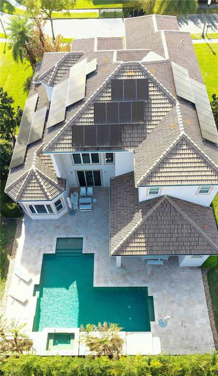 An aerial view shows a house with solar panels on the roof and a swimming pool — 6219 TIROCO WAY, WINDERMERE, FL