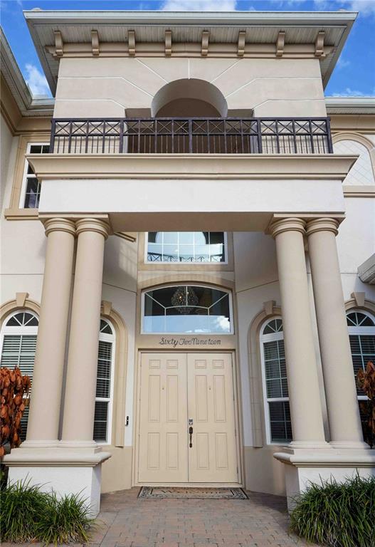 The exterior of a two-story house features a double front door under a balcony — 6219 TIROCO WAY, WINDERMERE, FL