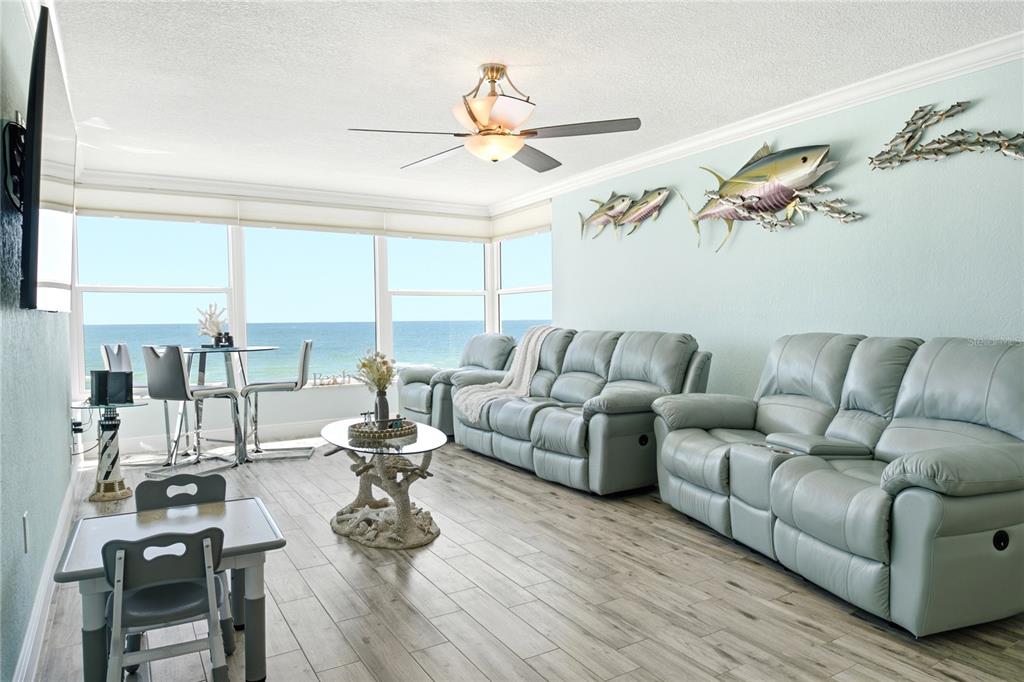 A living room with light blue walls, two leather sofas, and a view of the ocean — 14800 GULF BOULEVARD UNIT 303, MADEIRA BEACH, FL