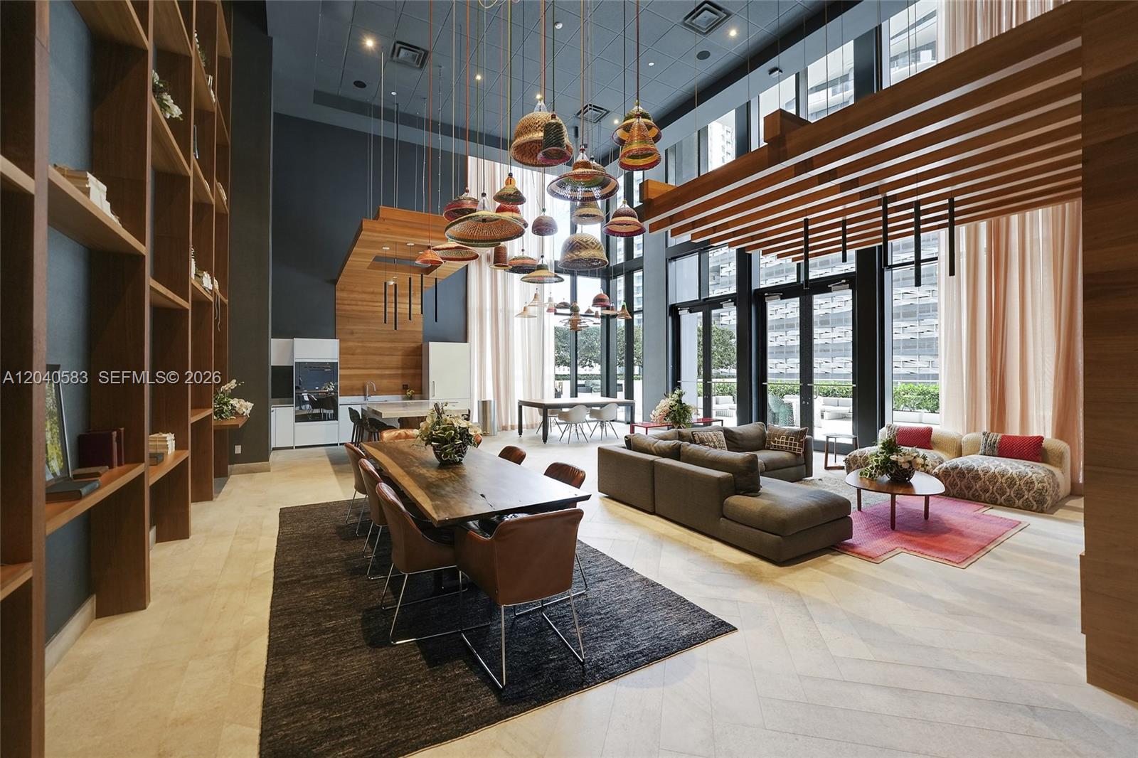 A spacious, high-ceilinged living and dining area features wooden shelving, pendant lights, and modern furniture — 1010 Brickell Ave # 3007, Miami FL 33131, MIAMI, FL