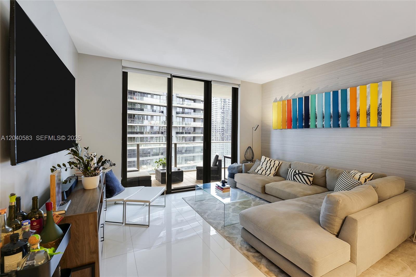 A modern living room features a sectional sofa, glass coffee table, and balcony access — 1010 Brickell Ave # 3007, Miami FL 33131, MIAMI, FL