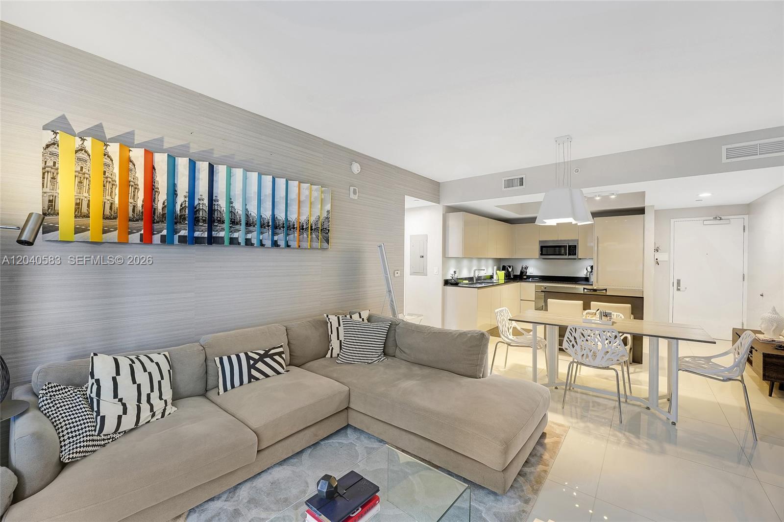 A modern open-concept living room features a beige sectional sofa, dining area, and kitchen — 1010 Brickell Ave # 3007, Miami FL 33131, MIAMI, FL