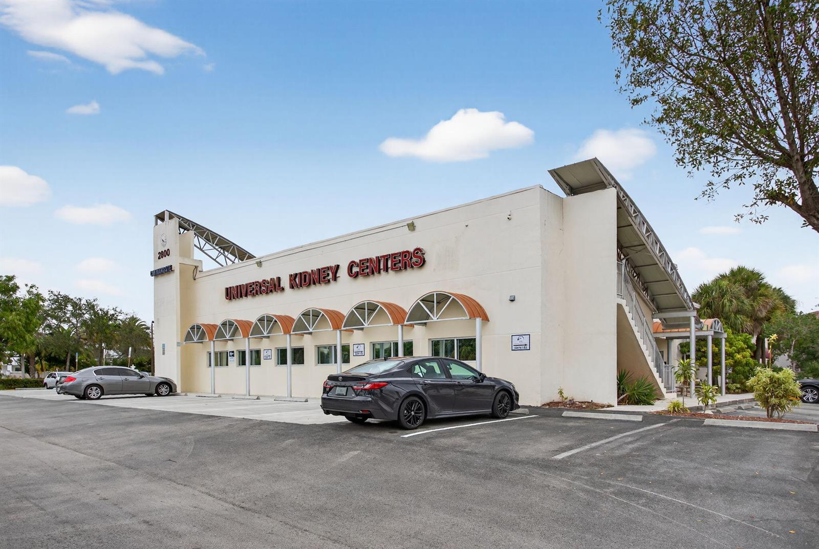 A two-story commercial building with a parking lot and a dark sedan parked outside — 2800 N State 7 Road, Margate FL 33063, MARGATE, FL