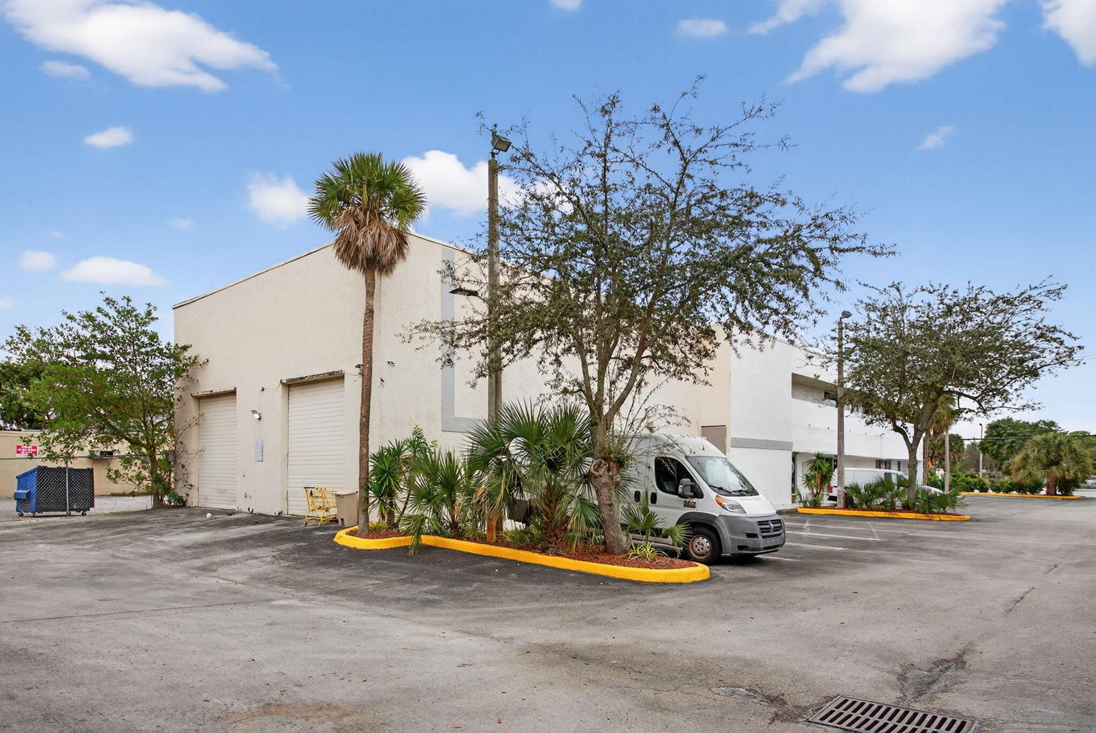 An exterior view of a commercial building with two roll-up doors and a parked van — 2800 N State 7 Road, Margate FL 33063, MARGATE, FL