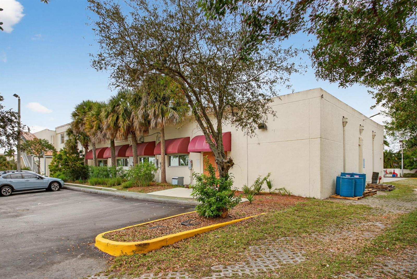 A low-rise commercial building features a beige stucco exterior with red fabric awnings — 2800 N State 7 Road, Margate FL 33063, MARGATE, FL