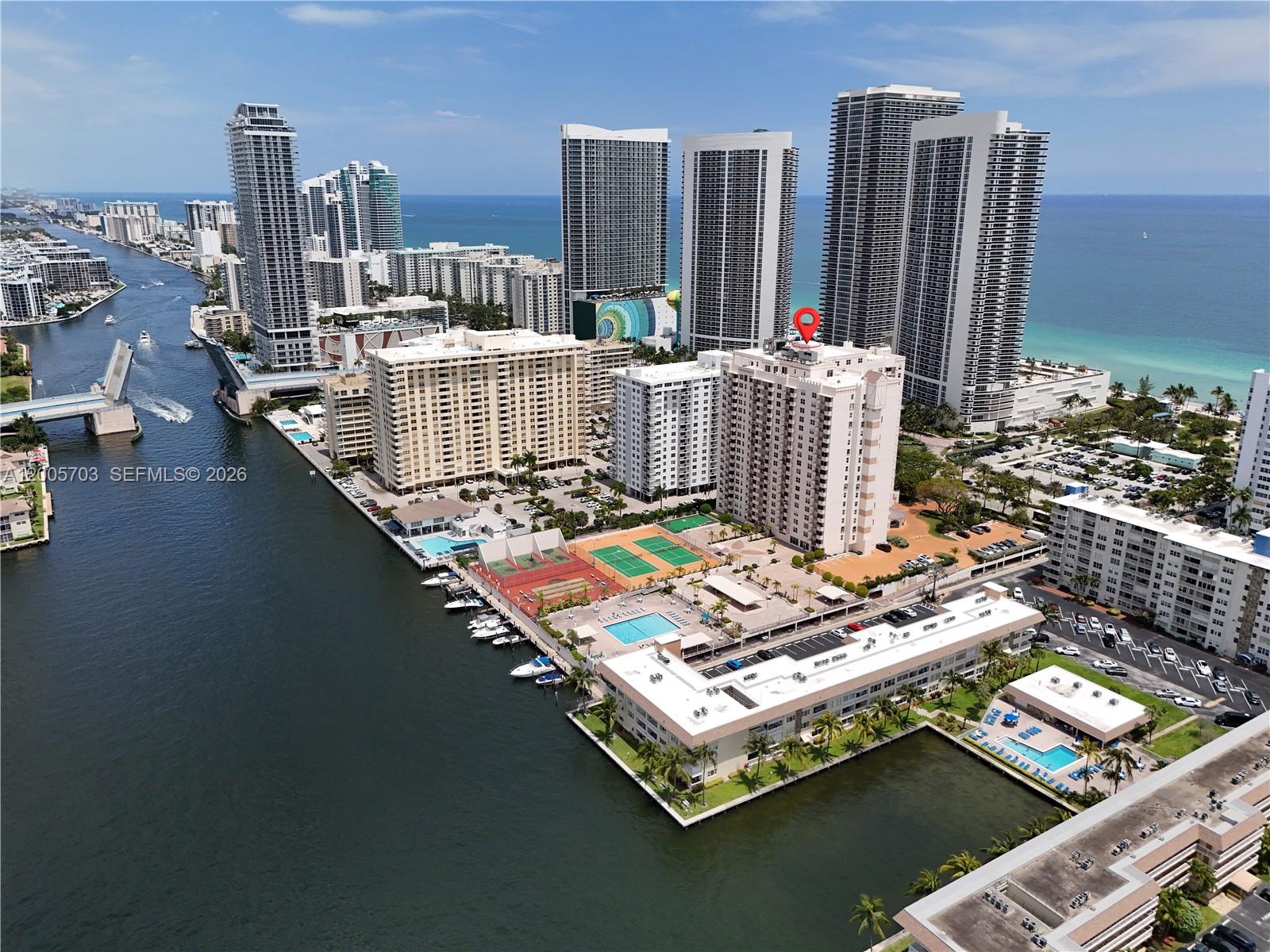 An aerial view shows high-rise residential buildings, a waterway, a drawbridge, and tennis courts — 1865 S Ocean Dr # 15B, Hallandale Beach FL 33009, HALLANDALE BEACH, FL