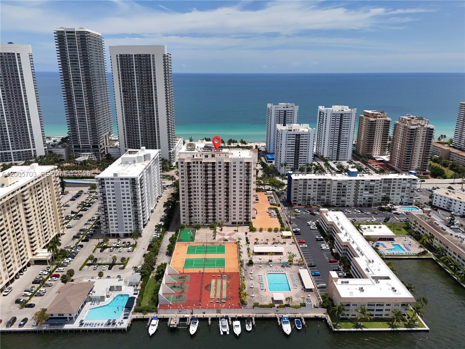 Aerial view of a coastal residential complex with tennis courts, swimming pools, and boat slips — 1865 S Ocean Dr # 15B, Hallandale Beach FL 33009, HALLANDALE BEACH, FL