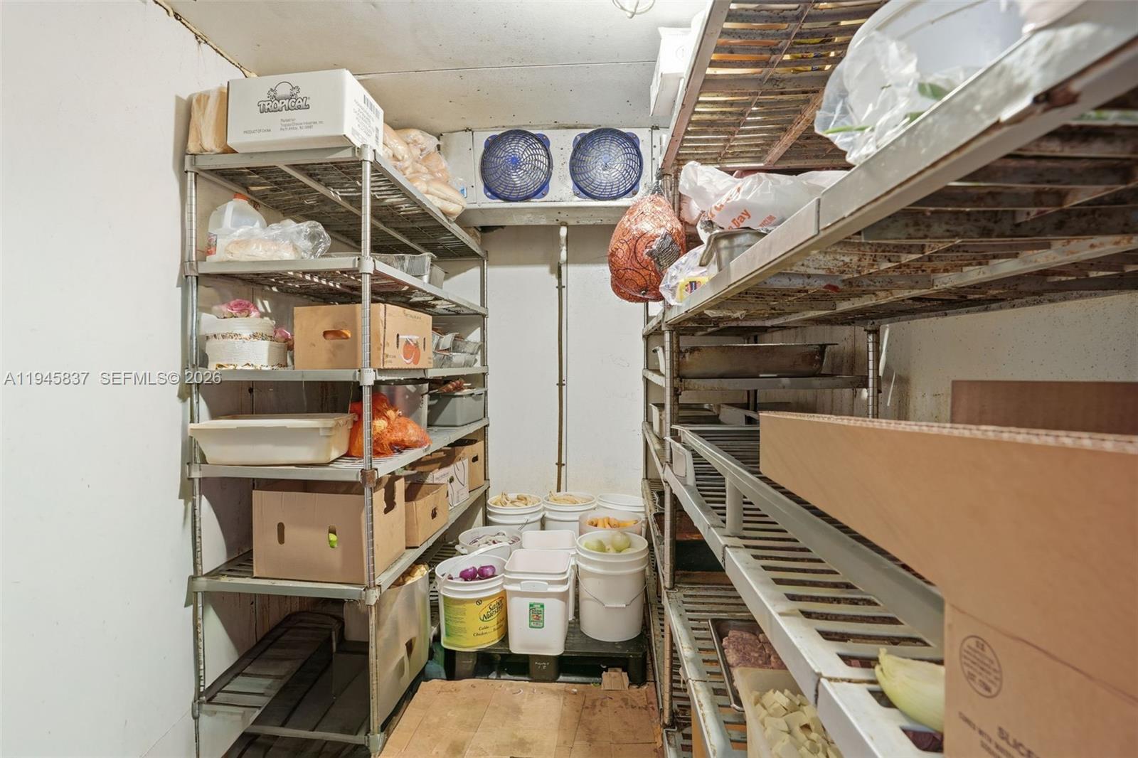 A walk-in cooler features metal shelving units filled with various food containers and produce — Confidential 76th St, Hialeah FL 33018, HIALEAH, FL