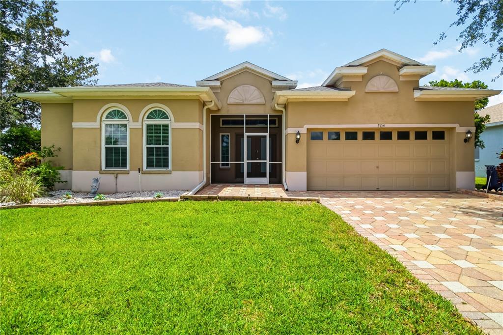 A tan single-story house with a paved driveway and a two-car garage — 5104 52ND AVENUE W, BRADENTON, FL