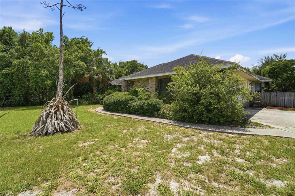 A single-story brick house with a large bush and a tall agave plant in front — 3006 ANNEZ WAY, DEBARY, FL