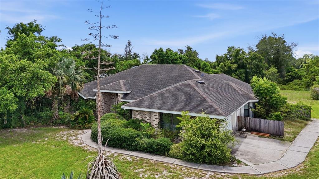 An aerial view of a single-story brick house with a dark shingled roof and landscaping — 3006 ANNEZ WAY, DEBARY, FL