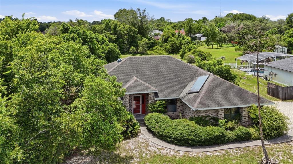An aerial view of a single-story brick house with a dark shingled roof and landscaping — 3006 ANNEZ WAY, DEBARY, FL