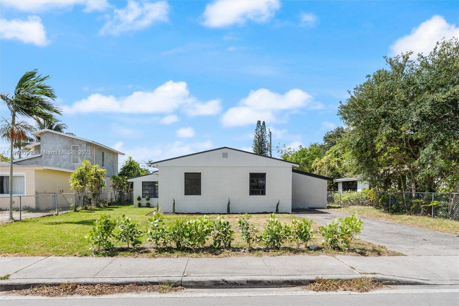 A single-story white brick house features a front lawn with small shrubs and a driveway — 3230 Taft St, Hollywood FL 33021, HOLLYWOOD, FL