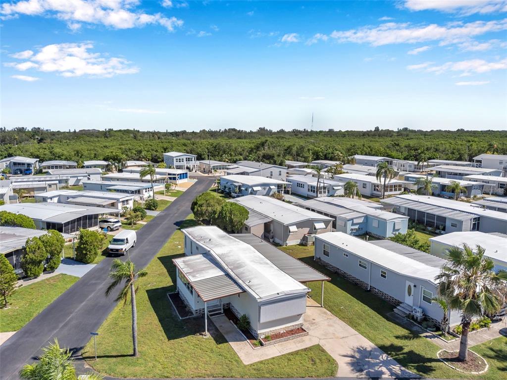 An aerial view shows a mobile home community with paved streets and surrounding green vegetation — 605 MOUNT LANCASTER AVENUE NE UNIT 634, ST PETERSBURG, FL