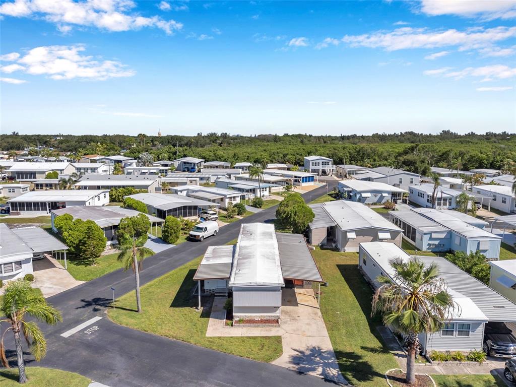 An aerial view shows a residential neighborhood of manufactured homes with paved streets and palm trees — 605 MOUNT LANCASTER AVENUE NE UNIT 634, ST PETERSBURG, FL