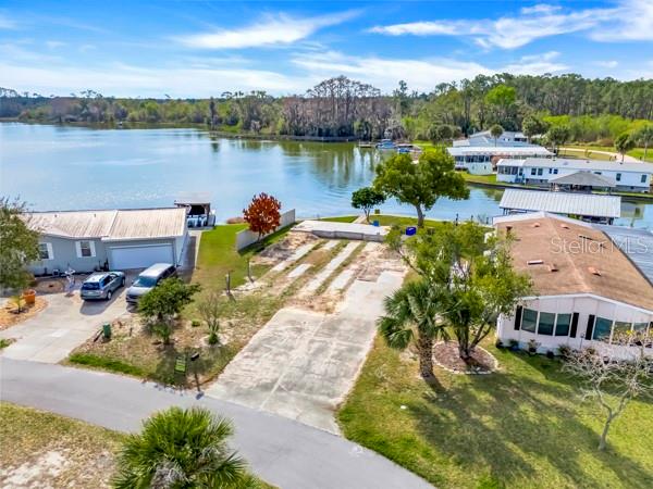 An aerial view shows two houses separated by a vacant lot near a lake — 1629 SUNSHINE LANE, TAVARES, FL